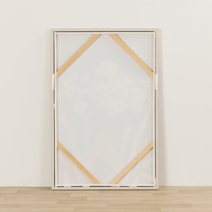 Framed abstract art piece with geometric design on a white wall.