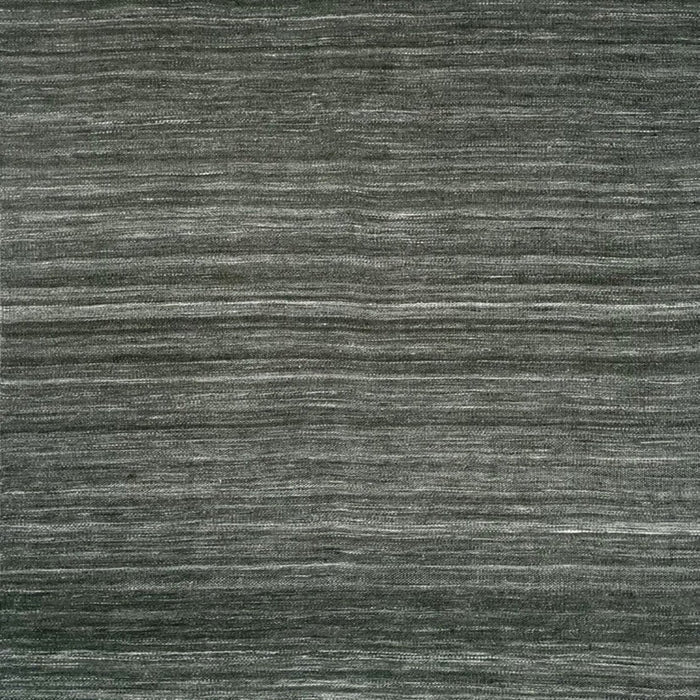 A close-up of a textured woven rug or fabric in dark charcoal gray with subtle horizontal tonal variation and white fringe along the top and bottom edges.