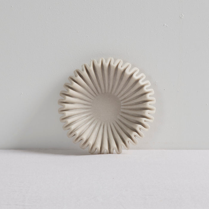 Ruffled Bowl - Bone, sculptural bone-coloured decorative bowl with a radial ruffled silhouette on a white surface