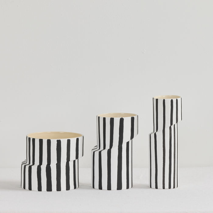 Twist Striped Medium Vase - White/Black, offset ceramic vase with hand-painted black vertical stripes, shown with matching vases.