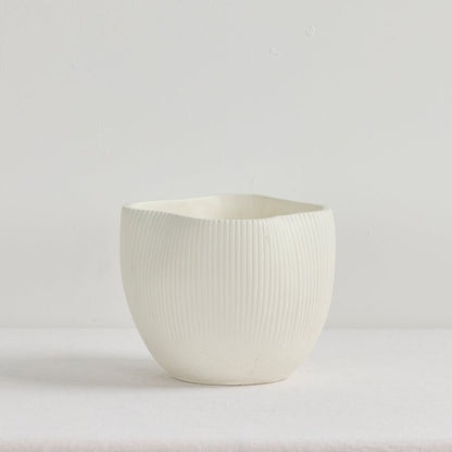 White ceramic cup with textured surface on a light gray background