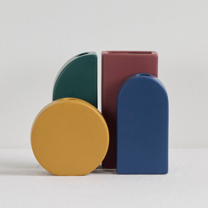 Arch Vase - Blue, sculptural blue ceramic vase with a rounded arch silhouette, styled alongside colourful vases
