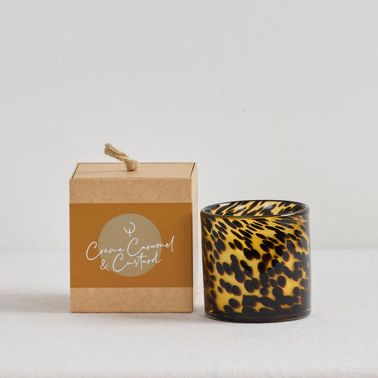 Aurora Candle -Crème Caramel & Custard-One home fragrance candle in a tortoiseshell glass vessel beside its caramel-toned box.