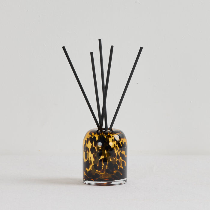 Aurora Diffuser - Crème Caramel & Custard reed diffuser with black reeds in a tortoiseshell glass vessel