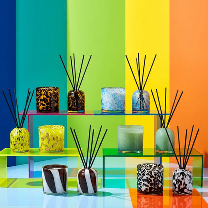Aurora Diffuser - Tobacco Leaf & Saffron reed diffuser in an organic striped glass vessel, styled with colourful home fragrance pieces