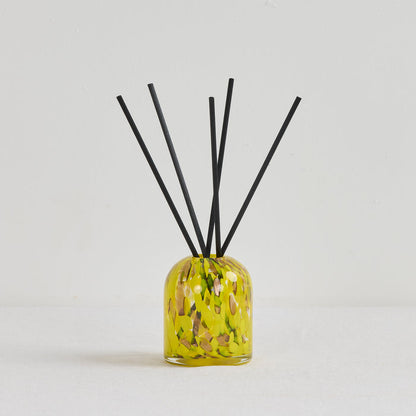 Aurora Diffuser - Tropical Crush reed diffuser in a mottled yellow glass vessel with black reeds