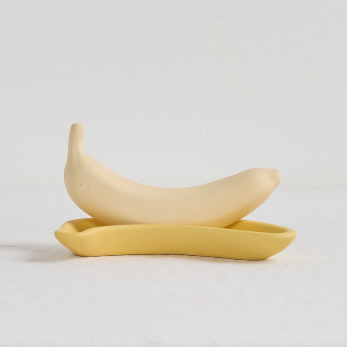 Two yellow ceramic spoons on a light gray background