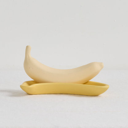Two yellow ceramic spoons on a light gray background