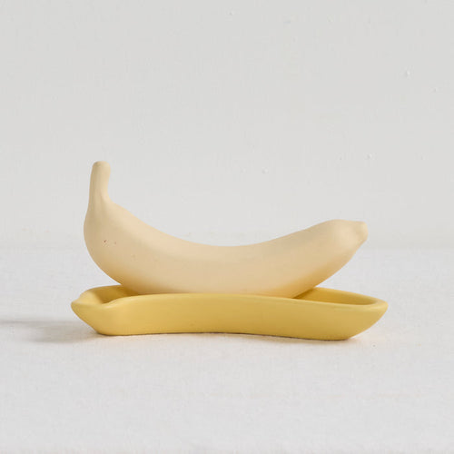 Two yellow ceramic spoons on a light gray background
