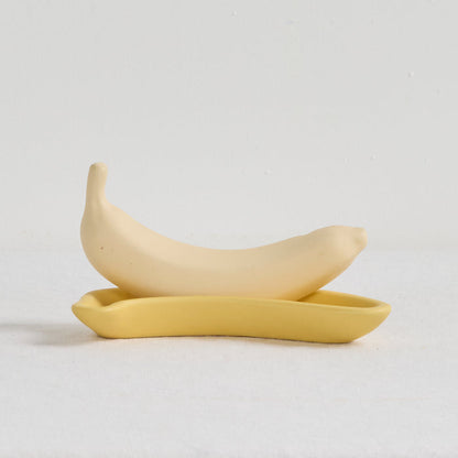Two yellow ceramic spoons on a light gray background