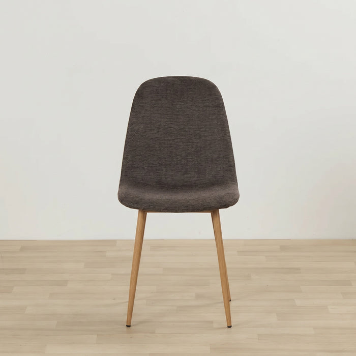 A modern dining chair with a dark brown textured fabric upholstered seat and back, supported by four tapered light wood legs, set against a minimalist off-white wall and light wood floor.