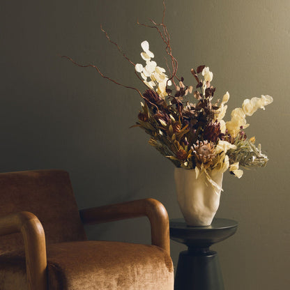 Corolle Vase - Bone, sculptural bone vase filled with dried foliage beside an armchair and side table