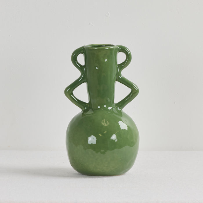 Green ceramic vase with two handles on a light gray background