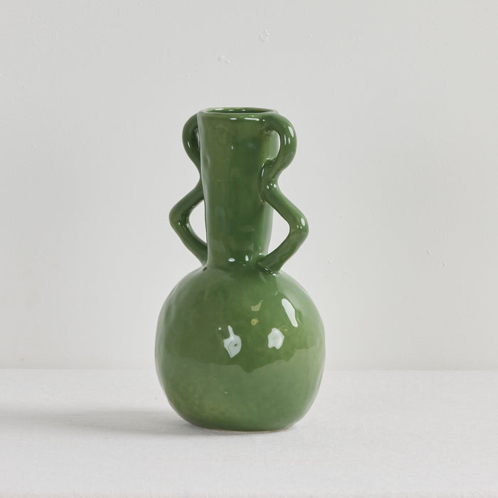 Green ceramic vase with two handles on a light gray background