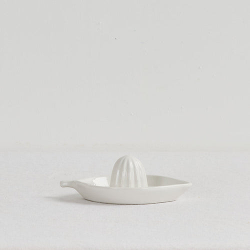 White ceramic citrus press on a light gray background