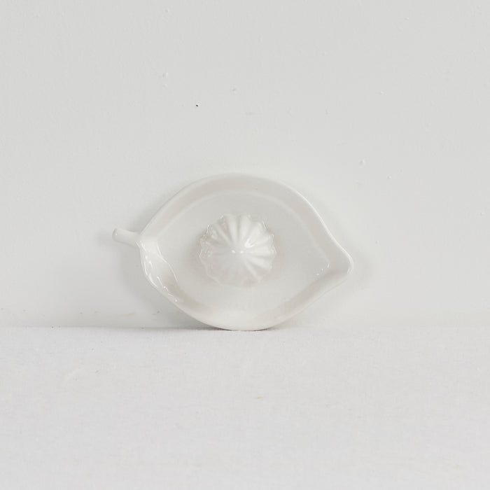 White ceramic lemon-shaped dish on a light gray background