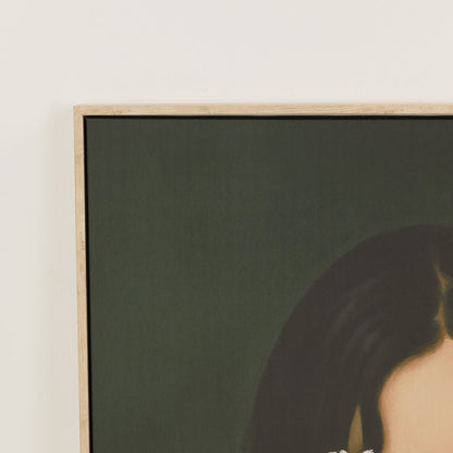 Framed artwork of a woman with dark hair on a plain wall