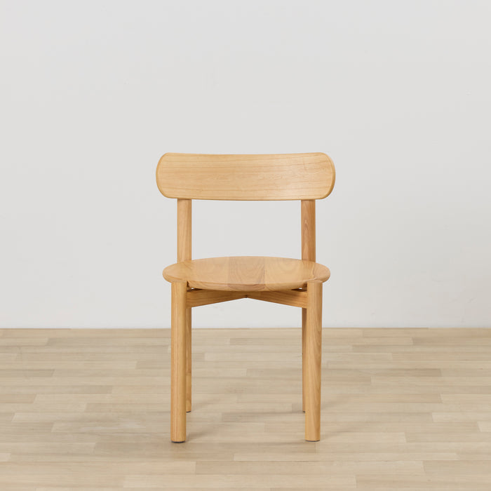 Maeve Dining Chair - Natural, solid wood dining chair with rounded seat and curved backrest on timber flooring