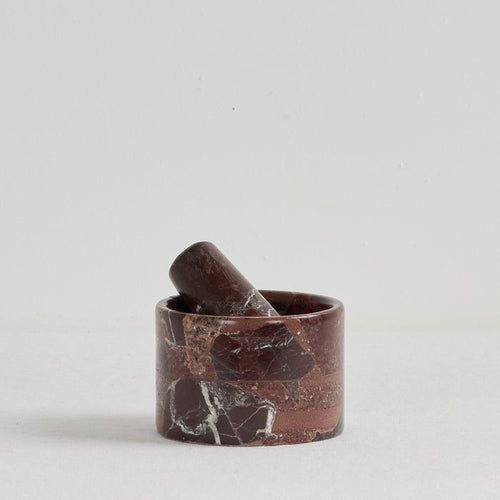 Marble-patterned mortar and pestle on a light gray background