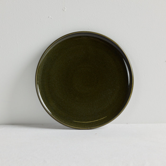 Green dinner plate on a white table cloth