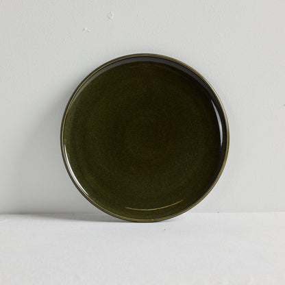 Green dinner plate on a white table cloth