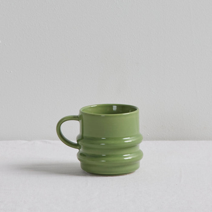 Green ceramic mug on a light gray background