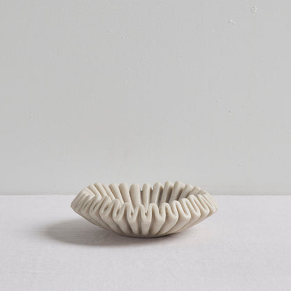 Ruffled Bowl - Bone, sculptural bone-coloured decorative bowl with a ruffled silhouette on a white surface