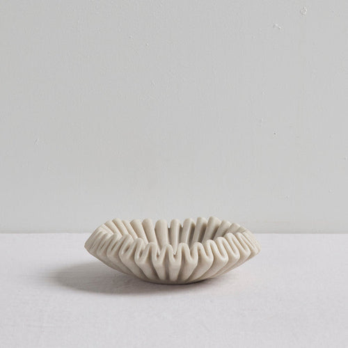 Ruffled Bowl - Bone, sculptural bone-coloured decorative bowl with a ruffled silhouette on a white surface