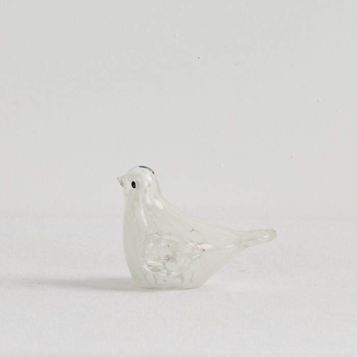 Glass bird figurine on a light gray background