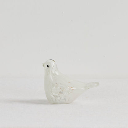 Glass bird figurine on a light gray background
