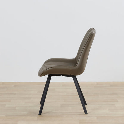 Beige chair on a wooden floor with a white wall background
