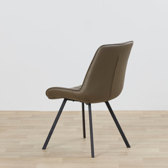 Brown chair with black legs on a wooden floor and light gray wall background