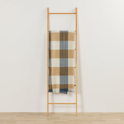 Tara Throw - Blue/Tan checked throw with fringe draped over a timber ladder in a minimalist room.