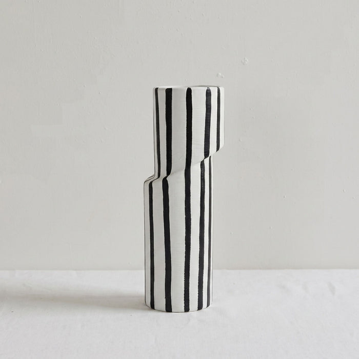 Black and white striped vase on a light gray background