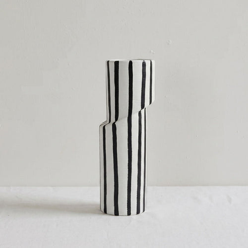 Black and white striped vase on a light gray background